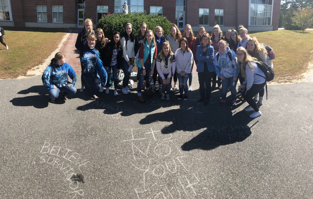 group of students gather to recongize domestic violence awareness week