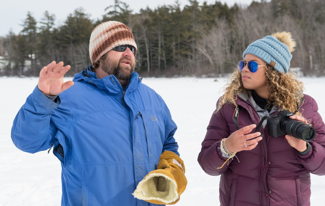 Art professor Scott Fuller instructs a student in digital photography outside on a frozen Sebago Lake