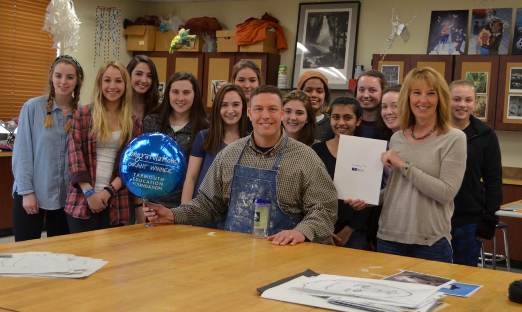 Principal Eric Klein MSEd '18 presents a Yarmouth Educational Foundation grant to an art class.
