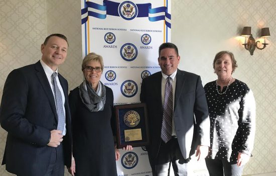 Dr. Andrew Dolloff, Betsy Lane, Ryan Gleason MSEd ’14, and Cathy Wolinsky accept the National Blue Ribbon School award in Washington, D.C.