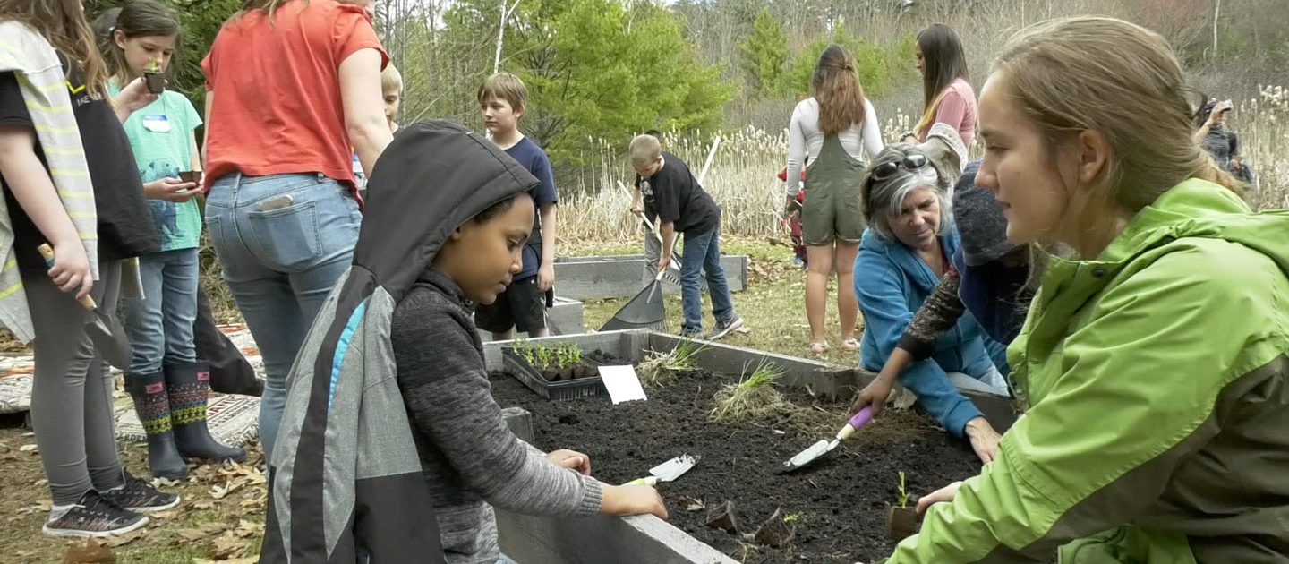 education students work with school children at the pollinator garden