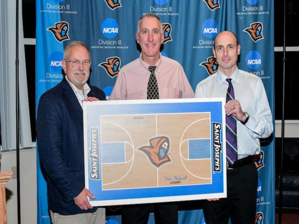 Dr. Jim Dlugos, college president, women's basketball head coach Mike McDevitt, and Brian Curtin, director of athletics